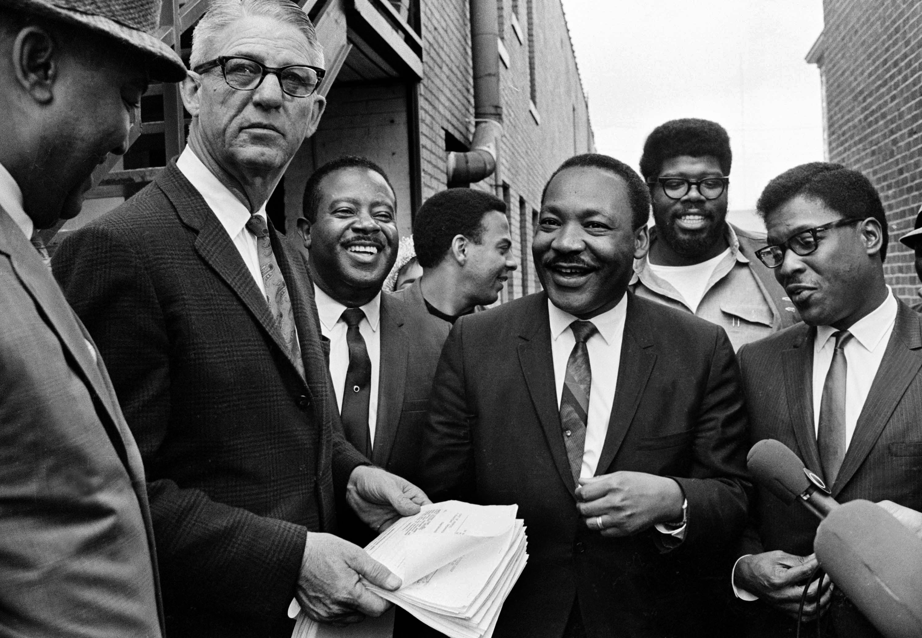 Dr. Martin Luther King Jr., center, and Rev. Ralph Abernathy, third from left, share a laugh outside court in Atlanta, Ga., Oct. 25, 1960.